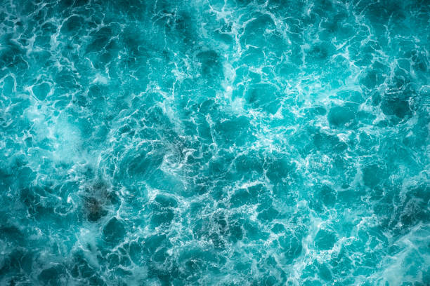 istock Texture Light blue surface of raging sea water with white foam and wave pattern 1341546395