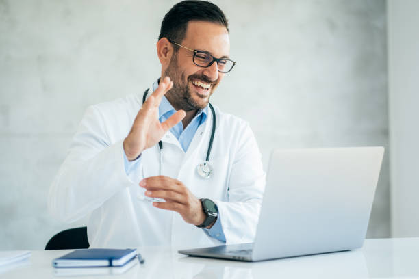 istock Doctor speaks with patient using laptop online 1341546413