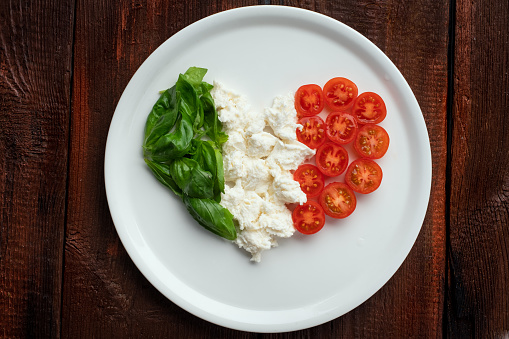 Ingredients for Caprese salad in the form of a heart. Italian flag from traditional food products
