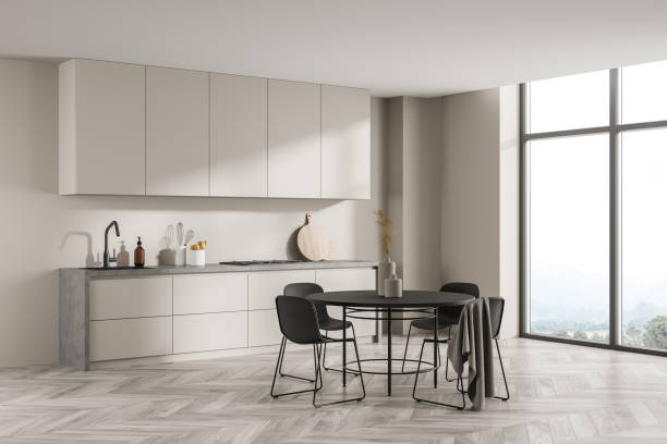 istock Corner view of minimalist light beige kitchen with round black dining table 1341548612