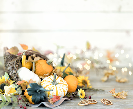 Autumn cornucopia with pumpkins, gourds and holiday decor arranged against an old wood background