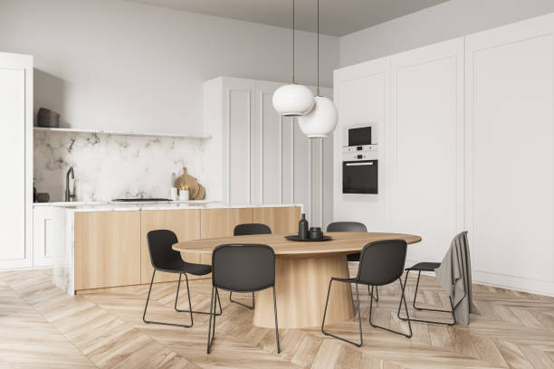 istock Corner of white kitchen with marble splashback and dining table 1341549033