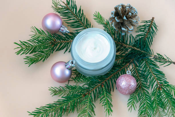 istock Open cream jar with fir branches and Christmas balls decorative flat lay backdrop. Winter season cosmetics advertisement, top view 1341555544