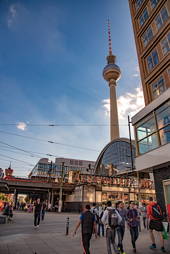 People walking at Alexanderplatz which is a large public square and transport hub in the central Mitte district of Berlin. Taken in Berlin, Germany on July 20, 2016