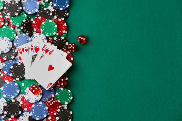 istock Casino chips, playing cards and dices on green fabric table 1341564365