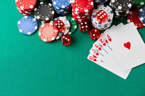 istock Casino chips, playing cards and dices on green fabric table 1341564387