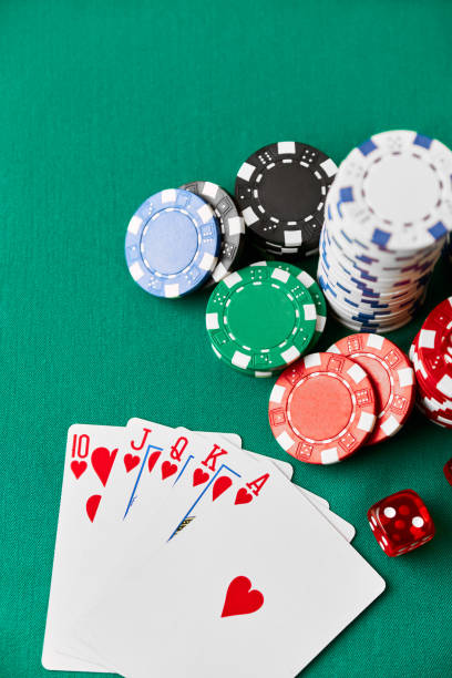 istock Casino chips, playing cards and dices on green fabric table 1341564479
