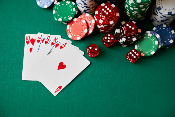 istock Casino chips, playing cards and dices on green fabric table 1341564531