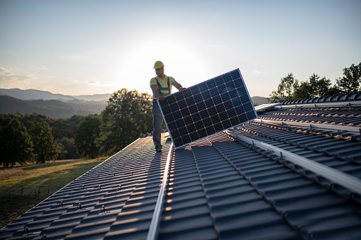 Trabajadores colocando paneles solares en un techo photo