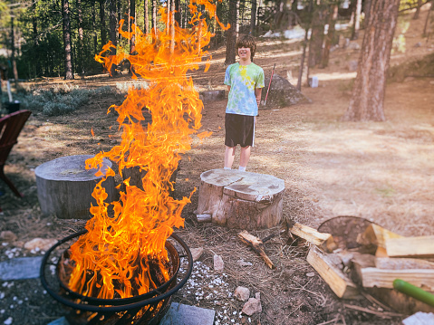 Child watching a fire burn in a backyard fire pit.