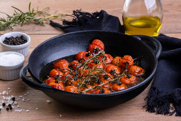 istock Iron casserole with confit tomatoes on wood table 1341565989