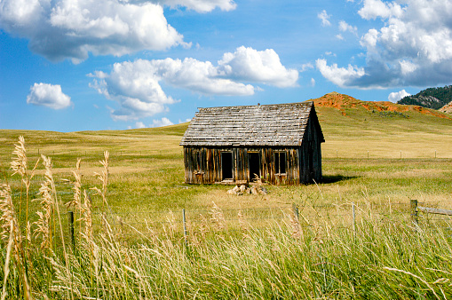 A lone broken down shack on the prairie sits deteriorating as the years go by and is left unattended.