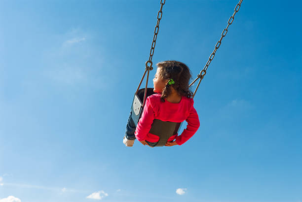 istock cute girl swinging 134157201
