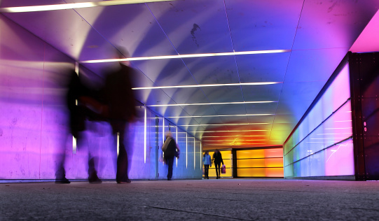 multi colored underground tunnel with people in motion