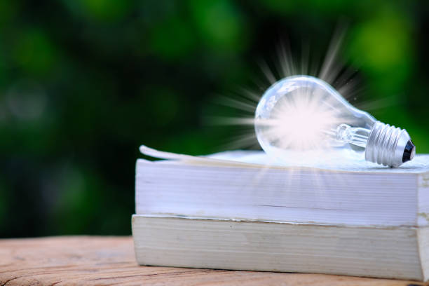 istock Idea innovation and inspiration concept. illuminated light bulb on table, concept 1341581795