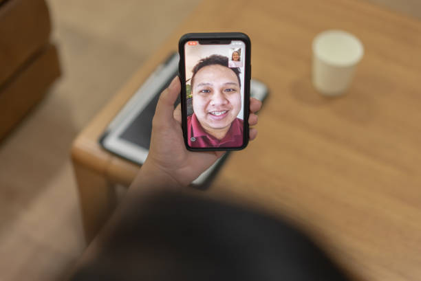 istock Focusing at hand with phone while a woman using video calling with husband 1341585479