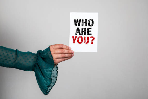 istock Who Are You. Note paper with a question in a woman's hands 1341586555