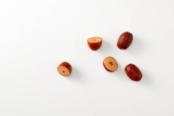Chinese red apple with sliced pieces isolated on white background. Top high angle view of ziziphus jujuba dry herbal medicine ingredient for food cooking