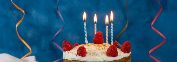 Photo of birthday cake with candles and streamer