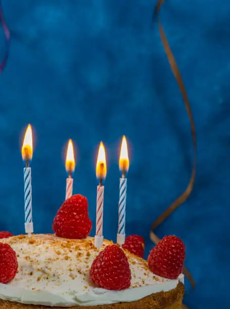 Photo of birthday cake with candles and streamer