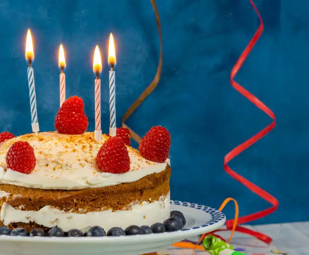 Photo of birthday cake with candles and streamer