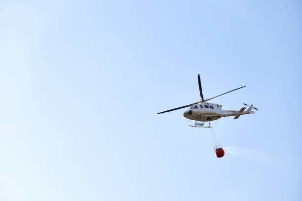 istock Firefighting helicopter transporting water to extinguish a fire. Hazard concept, climate change 1341594094