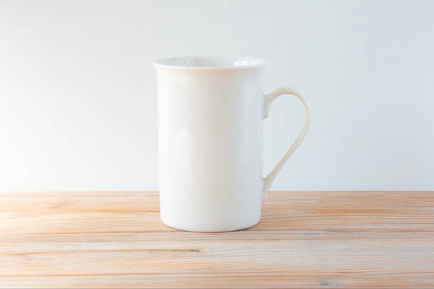 istock White tall cup on a wooden table. White mug mockup. 1341594107
