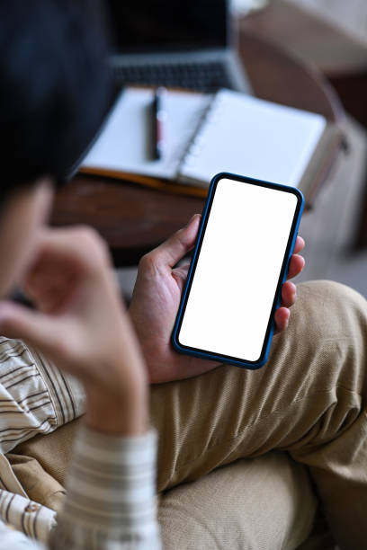 istock Young Asian man sitting at workplace and using mobile phone. 1341594214