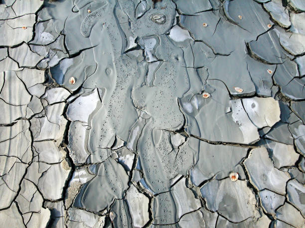 Cold clayey mud mixed with hydrocarbons, flowing down from a mud volcano Cold clayey mud mixed with hydrocarbons, flowing down from a mud volcano in the natural reserve of Salse of Nirano. Modena, Fiorano, Italy. mud volcano stock pictures, royalty-free photos & images