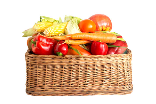 istock Basket with summer and autumn vegetables on a white background. Bell pepper, carrots and corn cobs with tomatoes, isolate. Autumn harvest 1341594310