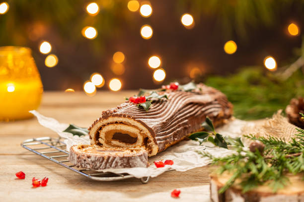gâteau de noël traditionnel, bûche de noël au chocolat avec décorations festives - bois coupé photos et images de collection