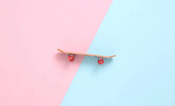 Photo of Mini finger skateboard blue pink pastel background