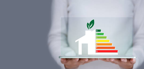 Energy efficiency and green energy concept, woman hand holding tablet and looking at house efficiency rating. Energy efficiency and green energy concept, woman hand holding tablet and looking at house efficiency rating. energy efficient stock pictures, royalty-free photos & images
