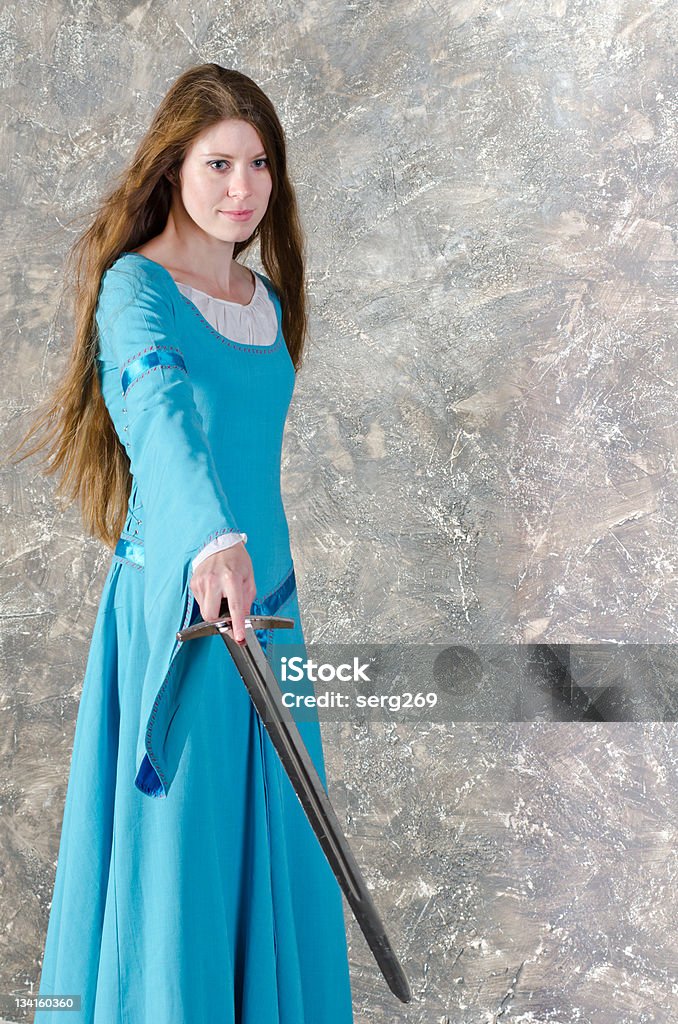 Giovane donna con spada posizioni - Foto stock royalty-free di Periodo medievale