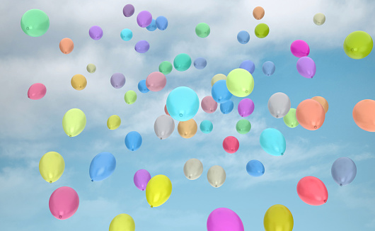 Balloons rising in the blue sky. Colorful balloons in the sky.