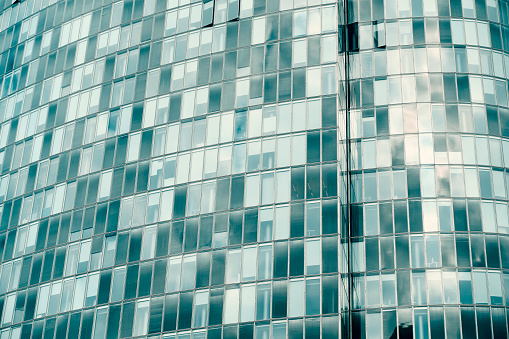 Toned photograph of the facade of a modern curved office building.