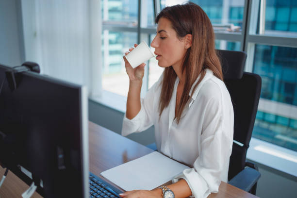 istock Businesswoman having coffee from paper cup 1341608045