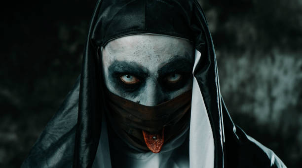 istock evil nun sticking out her tongue through her mask 1341610968
