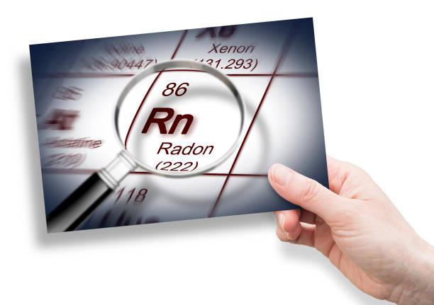 the danger of radon gas - concept with periodic table of the elements and magnifying lens and hand holding an postcard - magnifying glass lens holding europe imagens e fotografias de stock
