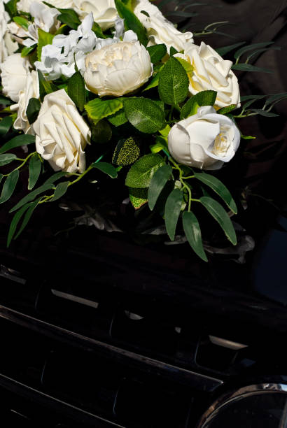 istock White wedding flowers attached to a black car. Wedding floristics and decorations close up. Wedding and holiday concept. 1341612991