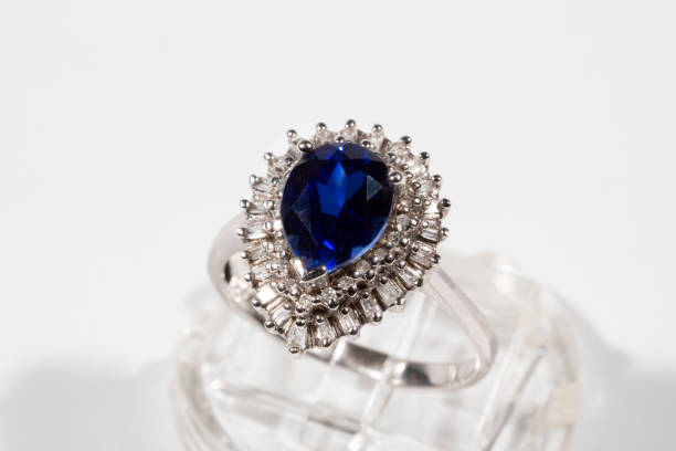 istock Diamond ring. Diamond ring with sapphire on white background. Ring with diamonds and large sapphire. Golden wedding rings 1341613292