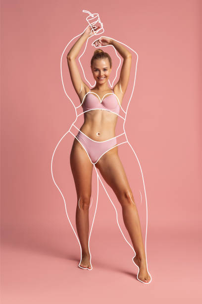 joven mujer hermosa con forma corporal perfecta en ropa interior aislada sobre fondo rosa. concepto de alimentación saludable - thin fotografías e imágenes de stock