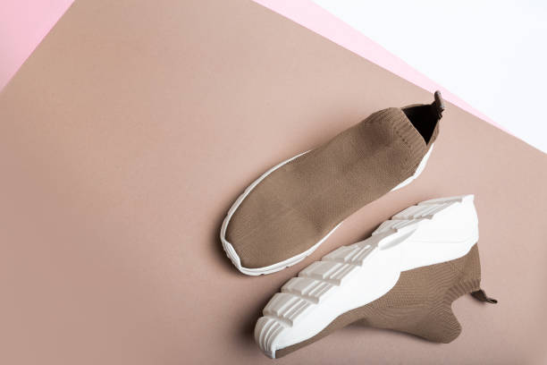 istock modern beige sneakers with white soles on beige background 1341618699