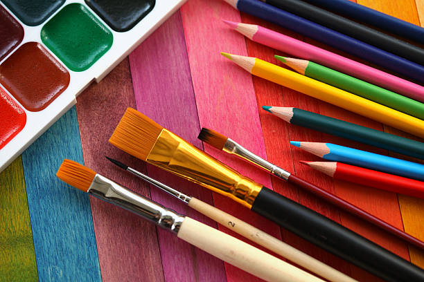 istock Paint next to an assortment of paintbrushes and pencils 134162124