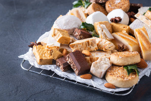 Typical Spanish Christmas sweets, shortbread mantecados, polvorones, nougat or turron Traditional Spanish Christmas sweets, shortbread mantecados and polvorones, nougat or turron on a table january in spanish stock pictures, royalty-free photos & images