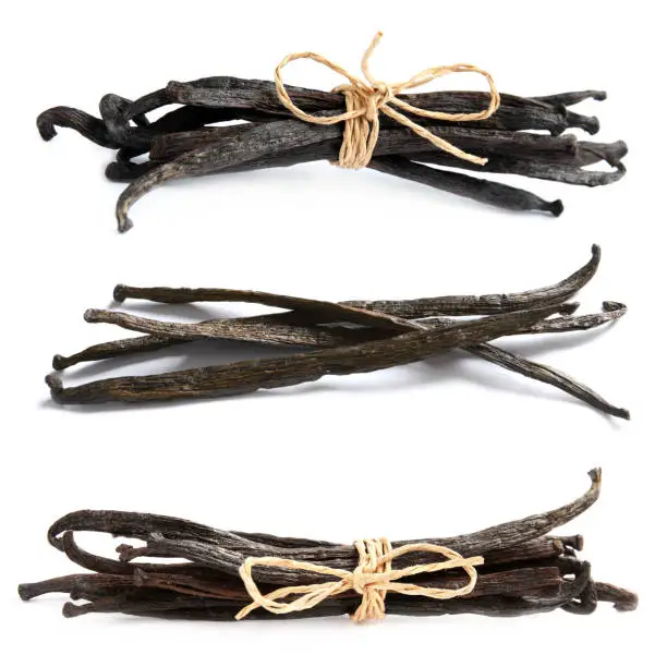 Set with dried vanilla pods on white background