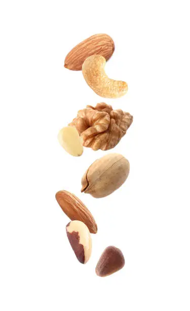 Photo of Different nuts falling on white background