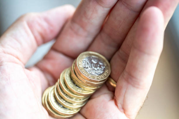 die hand des mannes, die einen stapel einer ein-pfund-münze hält - coin one pound coin british currency stack stock-fotos und bilder