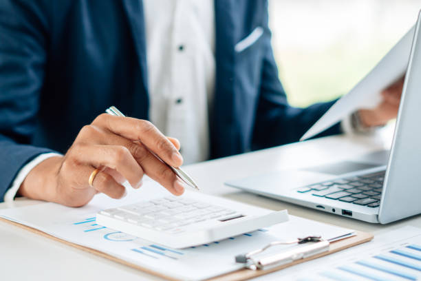 istock businessman working on desk office with using a calculator and laptop. 1341621769