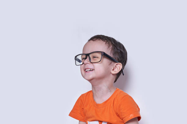 A cute little boy wearing big eyeglasses. Funny portrait of handsome 3-years-old multiracial kid. Cheerful child with big nerd eyeglasses